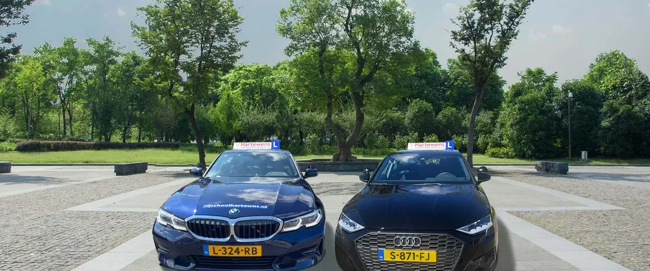 De lesauto's van Rijschool Hartewens: BMW 3 Serie en Audi A3 op een parkeerterrein in Hoofddorp